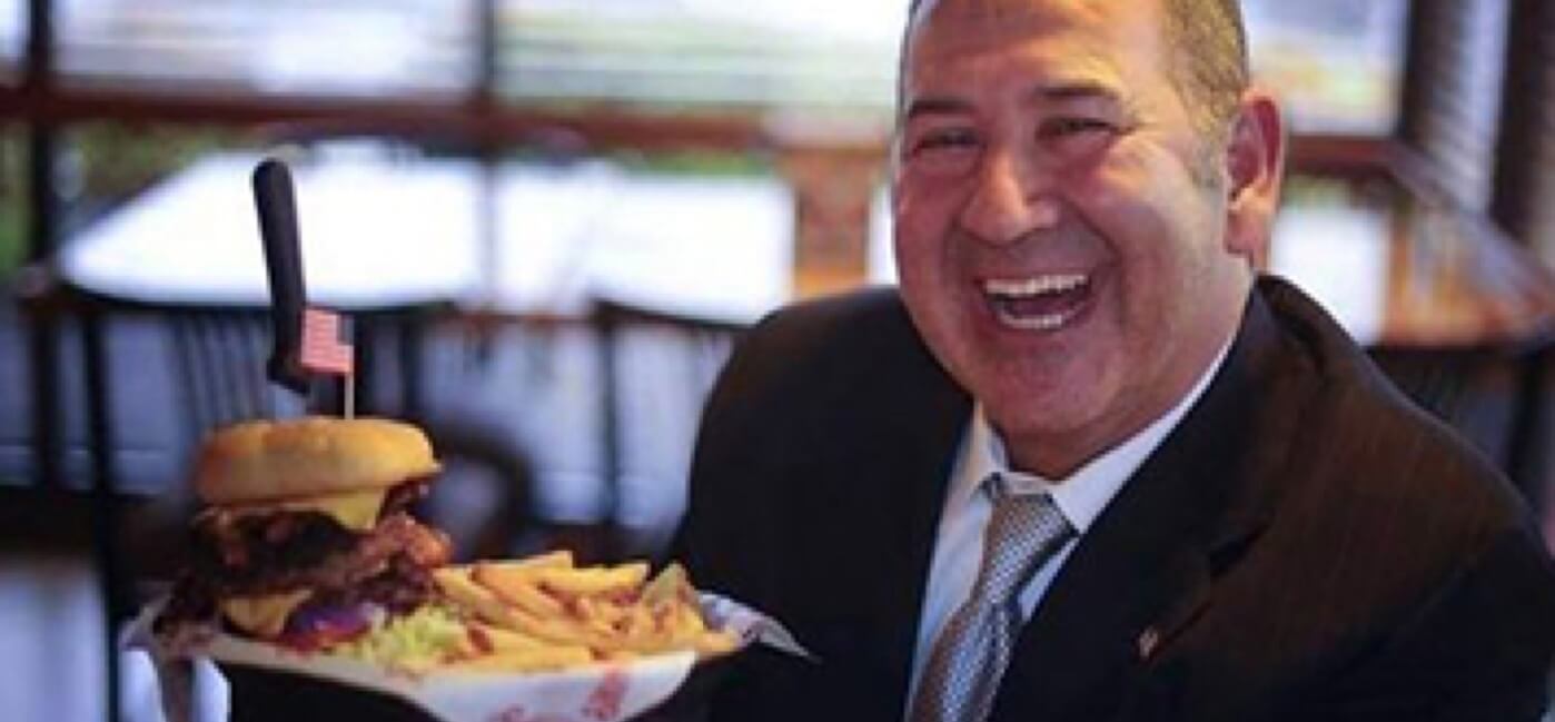 David Davoudpour holding an American Bacon Cheeseburger plate