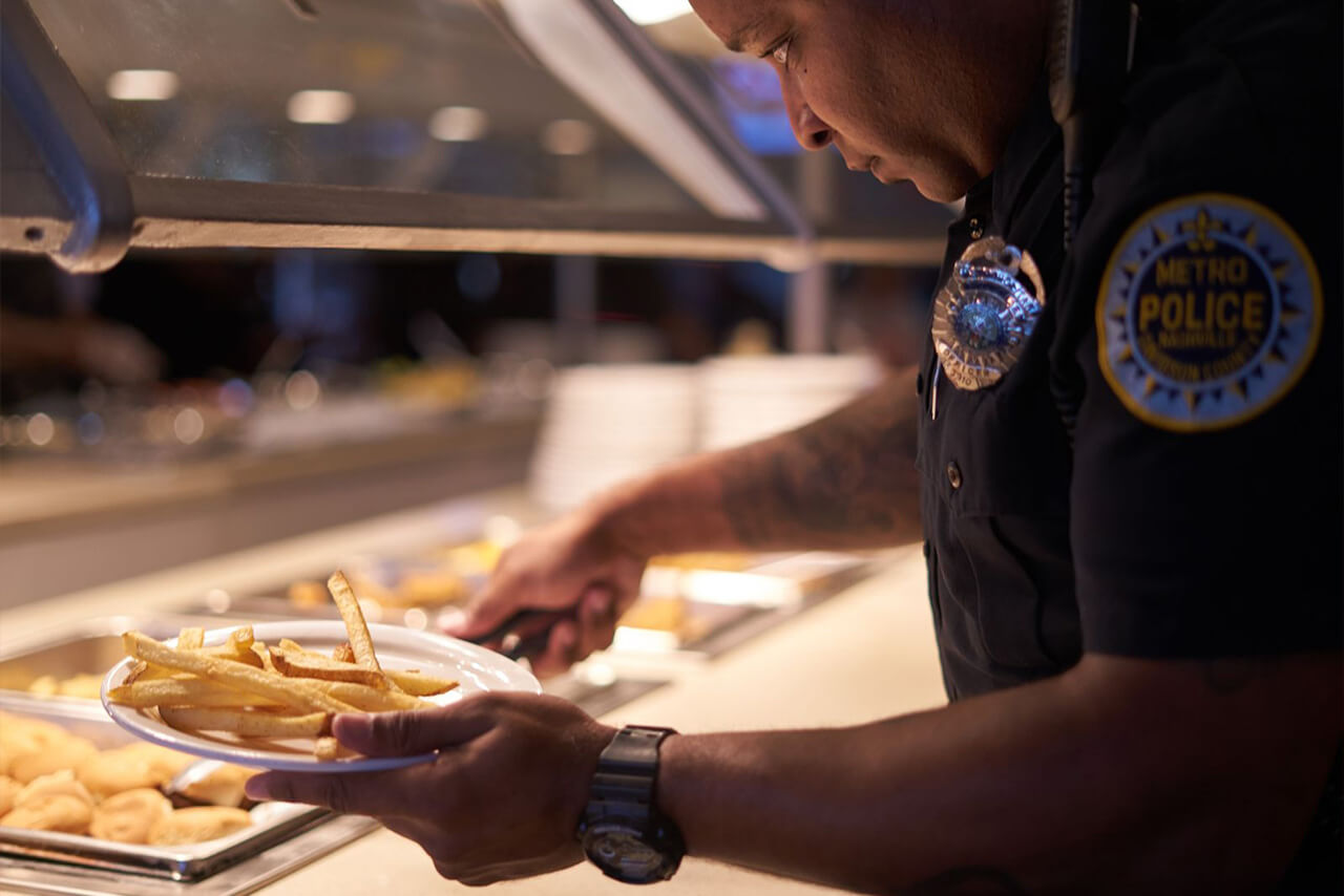 A Metro Nashville Police Officer getting fries from the Fresh Food Buffet.