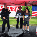 David Davoudpour giving a speech next to a police officer after the run.