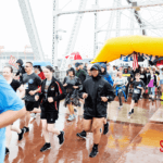 Various runners starting the 5k run while it's raining.