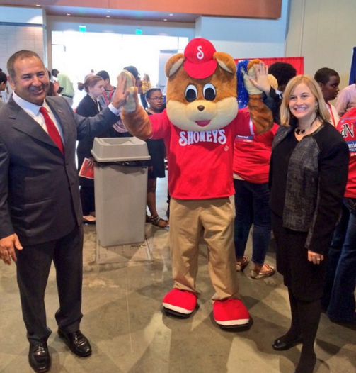 The Shoney's Bear giving a high five to Shoney's CEO and guest.